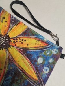 Zippered linen wristlet with artistic yellow daisy floral design